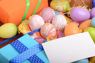 Image showing Arrangement of Gift Boxes in Wrapping Paper with Checkered Ribbons and Decorated Easter Eggs