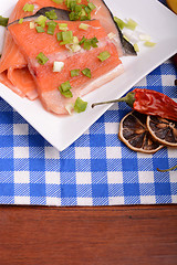 Image showing fresh salmon fillet on white plate. red pepper, cinnamon and lemon