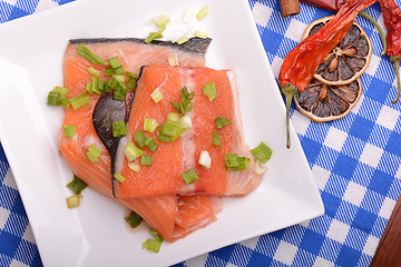 Image showing fresh salmon fillet on white plate. red pepper, cinnamon and lemon