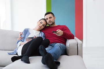 Image showing Young couple on the sofa watching television