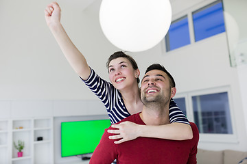 Image showing handsome man piggybacking his girlfriend