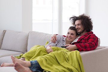 Image showing Young couple on the sofa watching television