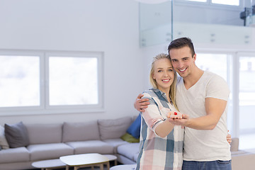 Image showing couple showing small red house in hands