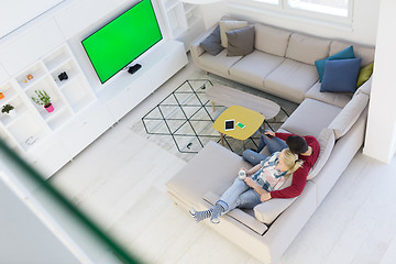 Image showing Young couple on the sofa watching television