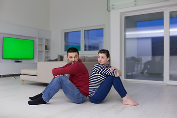 Image showing young couple sitting with back to each other on floor