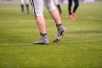 Image showing close up of american football players stretching and warming up