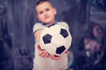 Image showing happy boy holding a soccer ball in front of chalkboard