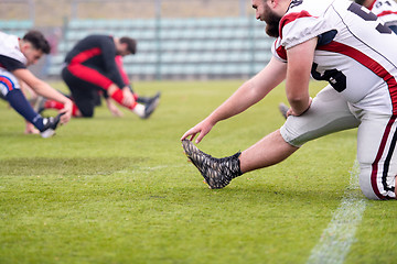 Image showing american football players stretching and warming up