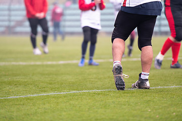 Image showing close up of american football players stretching and warming up