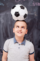 Image showing happy boy holding a soccer ball on his head