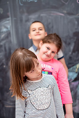 Image showing group of kids standing in front of chalkboard