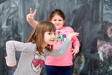 Image showing little girls having fun in front of chalkboard