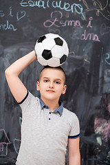 Image showing happy boy holding a soccer ball on his head