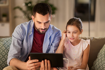 Image showing father and daughter listening to music on tablet