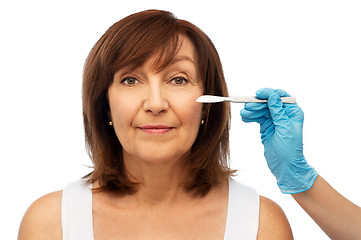 Image showing senior woman and surgeon hands with scalpel