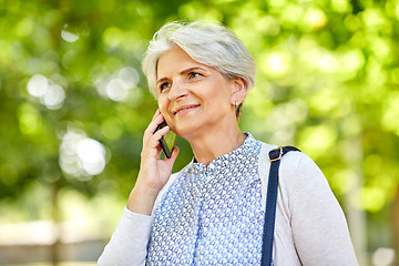 Image showing senior woman calling on smartphone in summer park