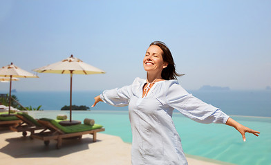 Image showing happy woman enjoying sun over infinity edge pool