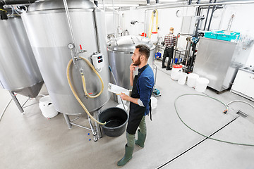 Image showing man with clipboard at craft brewery or beer plant