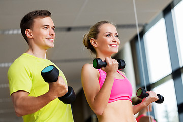 Image showing couple with dumbbells exercising in gym