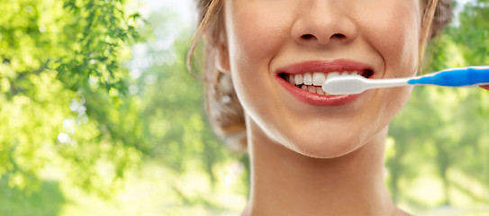 Image showing close up of woman with toothbrush cleaning teeth