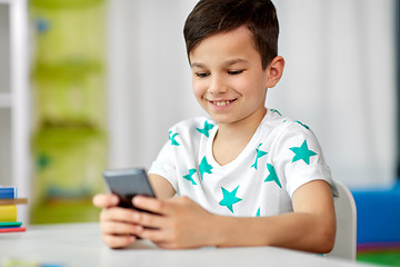 Image showing happy boy with smartphone at home