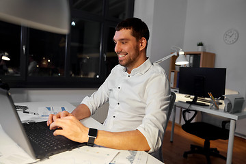 Image showing businessman with laptop working at night office