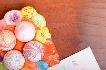 Image showing Easter eggs and white paper on a wooden background