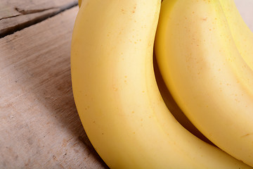 Image showing bunch of yellow Bananas in a Wooden background