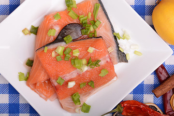 Image showing fresh salmon fillet on white plate. red pepper, cinnamon and lemon