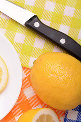 Image showing Halved lemon and a knife on a white plate