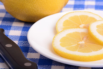 Image showing Halved lemon and a knife on a white plate