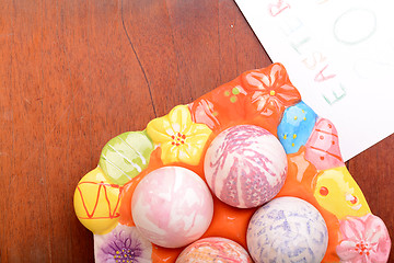 Image showing Easter eggs and white paper on a wooden background