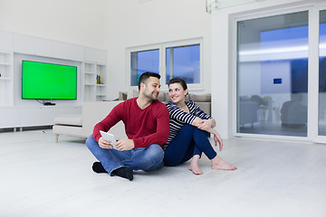 Image showing Young Couple using digital tablet on the floor