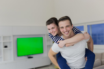 Image showing handsome man piggybacking his girlfriend