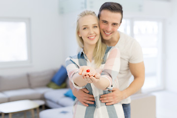 Image showing couple showing small red house in hands