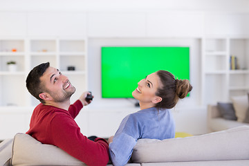 Image showing Young couple on the sofa watching television