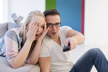 Image showing Young couple on the sofa watching television