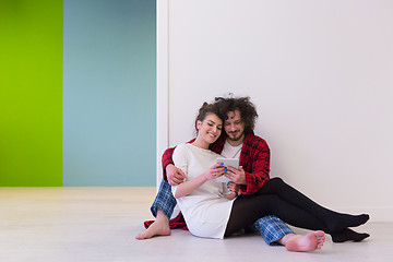 Image showing Young Couple using digital tablet on the floor