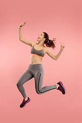 Image showing Full length of pretty young woman with mobile phone while jumping