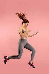 Image showing Full length of pretty young woman with mobile phone while jumping