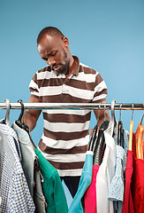 Image showing Handsome man with beard choosing shirt in a shop