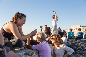 Image showing Indian tourists taking photos of colorful Oia village on Santorini island, Greece.