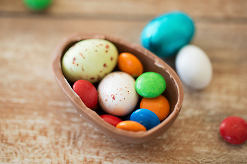 Image showing chocolate easter egg and candy drops on table