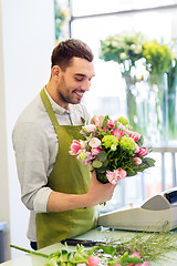 Image showing smiling florist man making bunch at flower shop