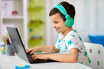 Image showing boy in headphones playing video game on laptop