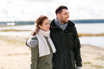 Image showing smiling couple hugging on autumn beach