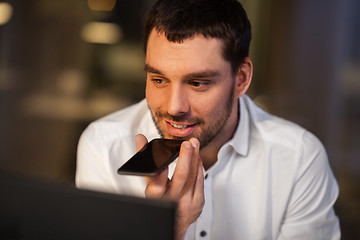 Image showing businessman recording voice message on smartphone