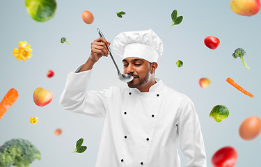 Image showing happy male indian chef tasting food from ladle