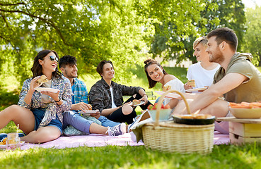 Image showing happy friends eating sandwiches at summer picnic