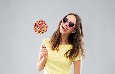 Image showing teenage girl in sunglasses with lollipop